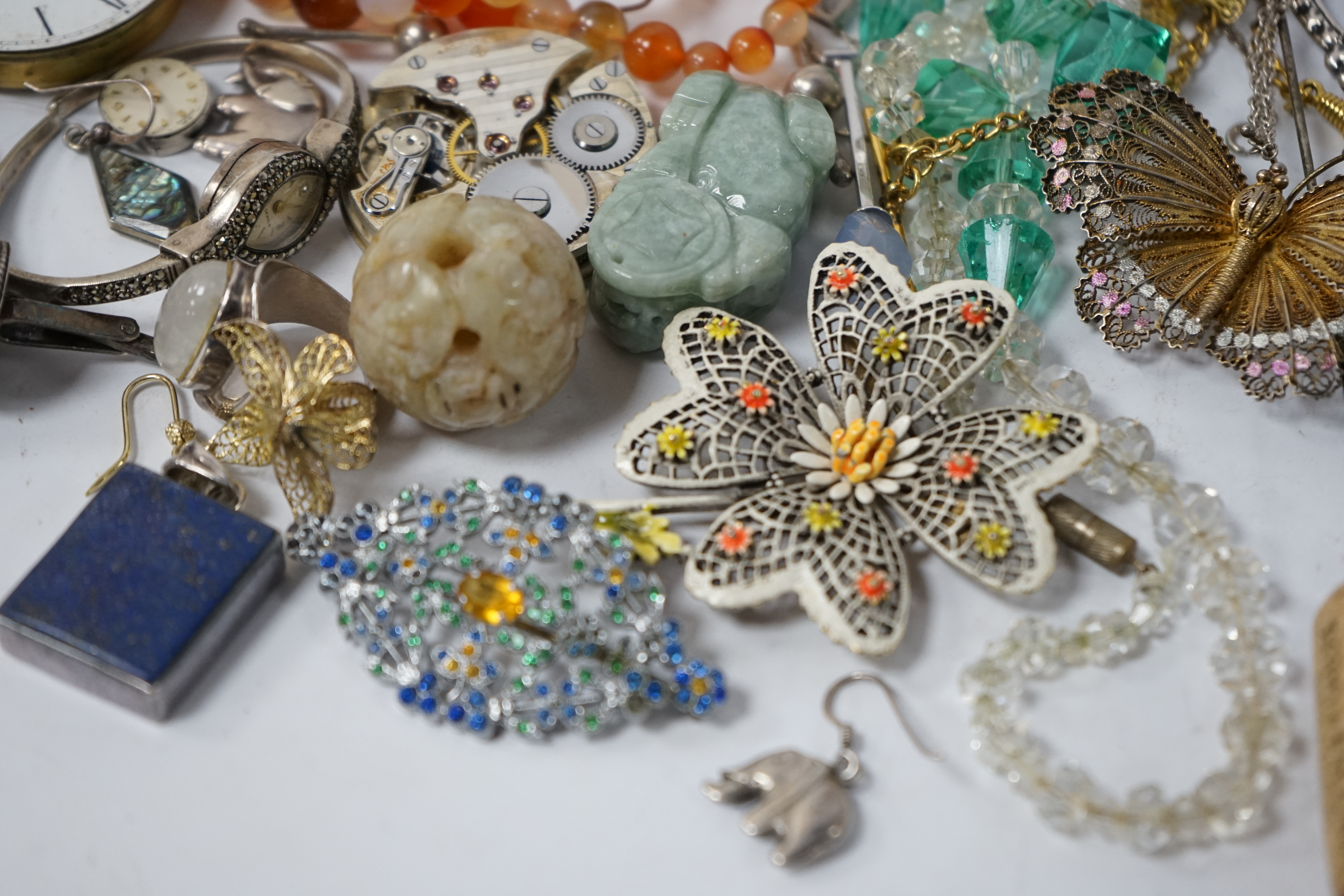 A small quantity of assorted jewellery and other items including a filigree butterfly brooch, a 925 and labradorite ring, an agate bead necklace, pocket watch movements, etc. Condition - poor to fair